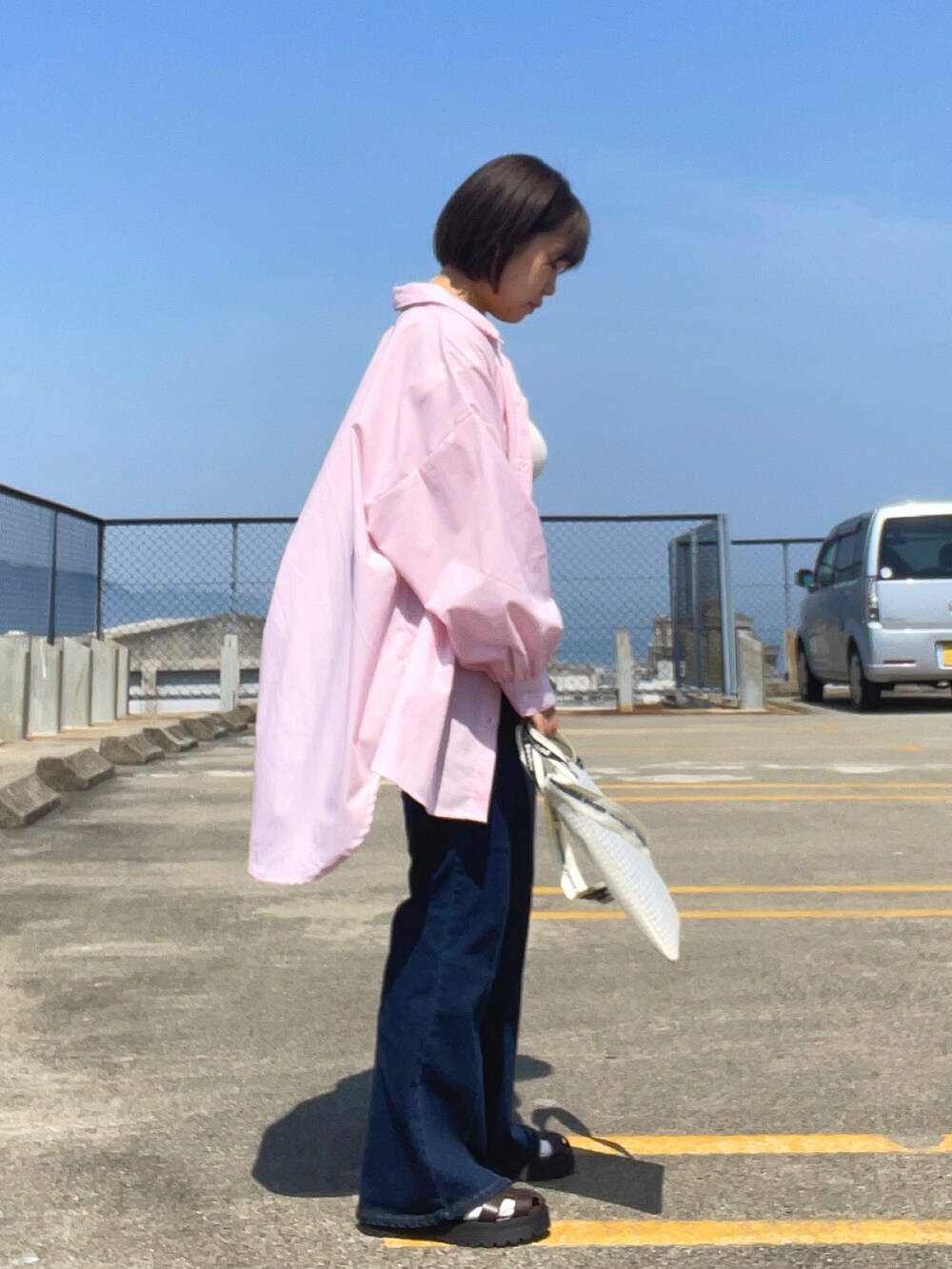 ホワイト系のタンクトップ、ピンク系のシャツ/ブラウス、ブルー系のデニムパンツを着用したレディースの春コーディネートの3枚目の写真