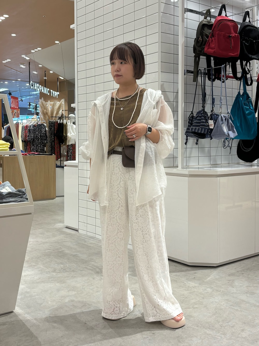 ホワイト系のサンダル、ホワイト系のその他パンツ、ブラウン系のショルダーバッグを着用したレディースの夏コーディネートの2枚目の写真