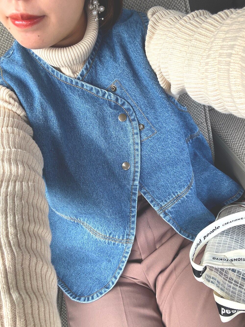 ホワイト系のニット/セーター、ブルー系のベスト、その他のショルダーバッグを着用したレディースの冬コーディネートの3枚目の写真