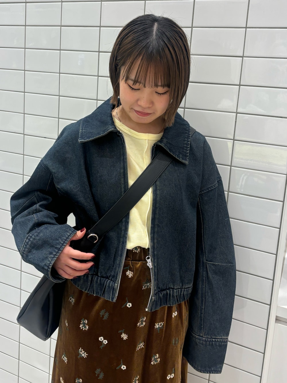 イエロー系のTシャツ/カットソー、ブルー系のデニムジャケット、ブラック系のスカートを着用したレディースの春コーディネートの4枚目の写真