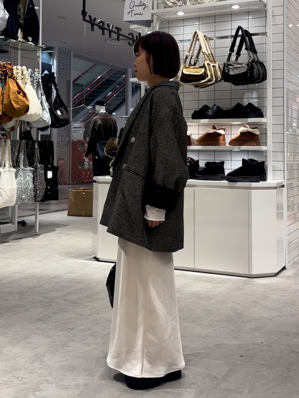 ホワイト系のスカート、ブラック系のブーツ、ホワイト系のTシャツ/カットソーを着用したレディースの秋コーディネートの3枚目の写真