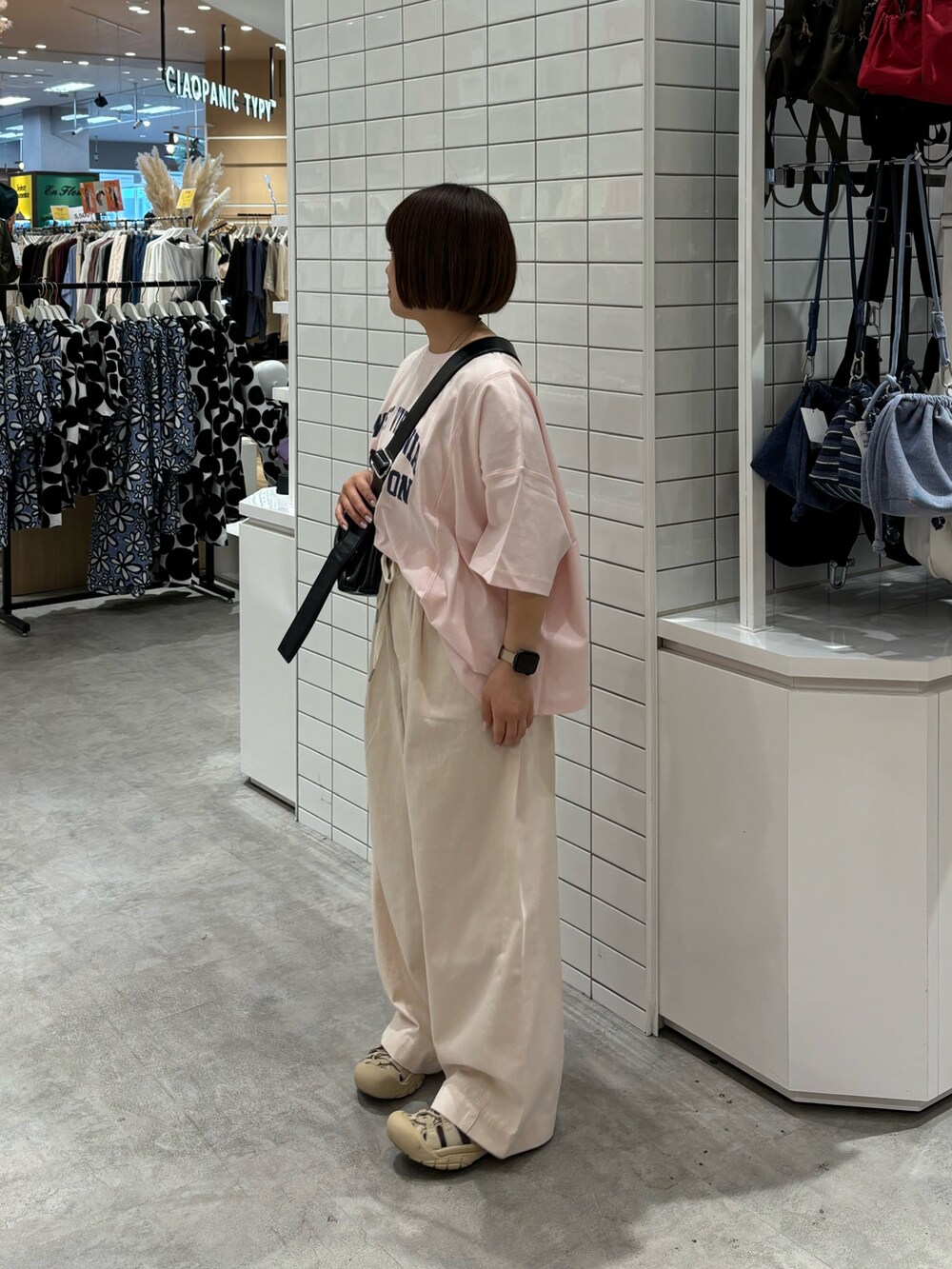 ホワイト系のデニムパンツ、ピンク系のTシャツ/カットソー、ブラック系のショルダーバッグを着用したレディースの夏コーディネートの2枚目の写真