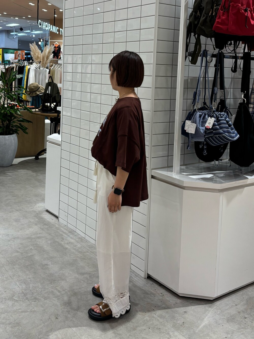 ブラウン系のTシャツ/カットソー、ブラウン系のサンダル、ホワイト系のその他パンツを着用したレディースの夏コーディネートの2枚目の写真