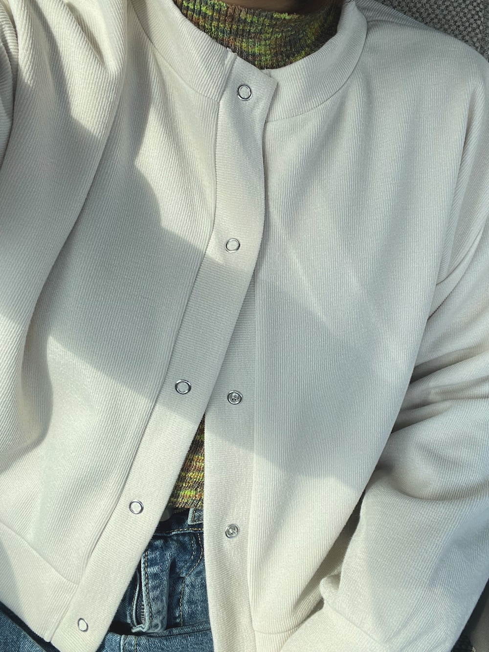 その他のショルダーバッグ、ホワイト系のカーディガン/ボレロ、ブルー系のデニムパンツを着用したレディースの冬コーディネートの2枚目の写真