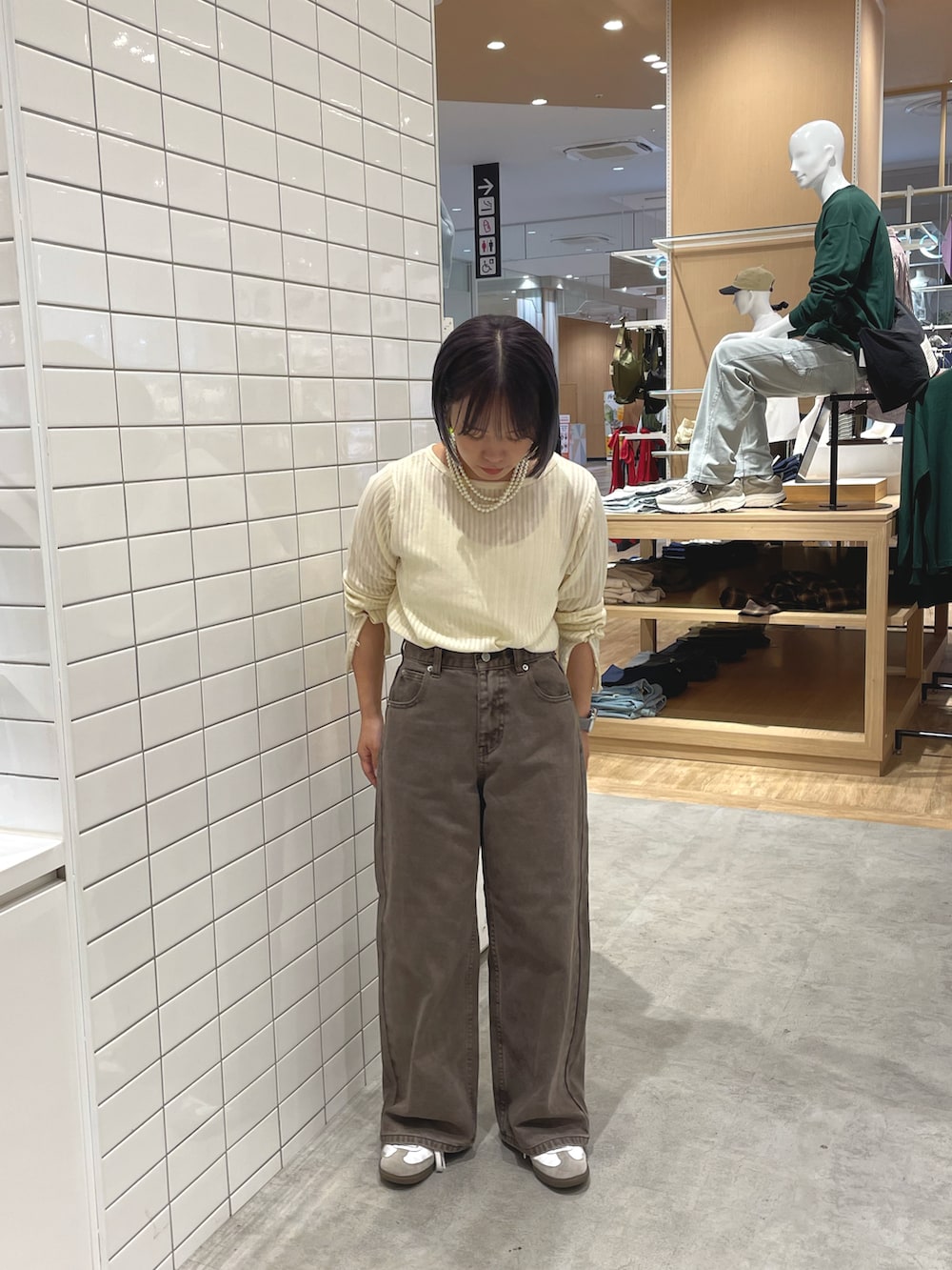 ホワイト系のスニーカー、ホワイト系のカーディガン/ボレロ、ブラウン系のデニムパンツを着用したレディースの秋コーディネートの2枚目の写真