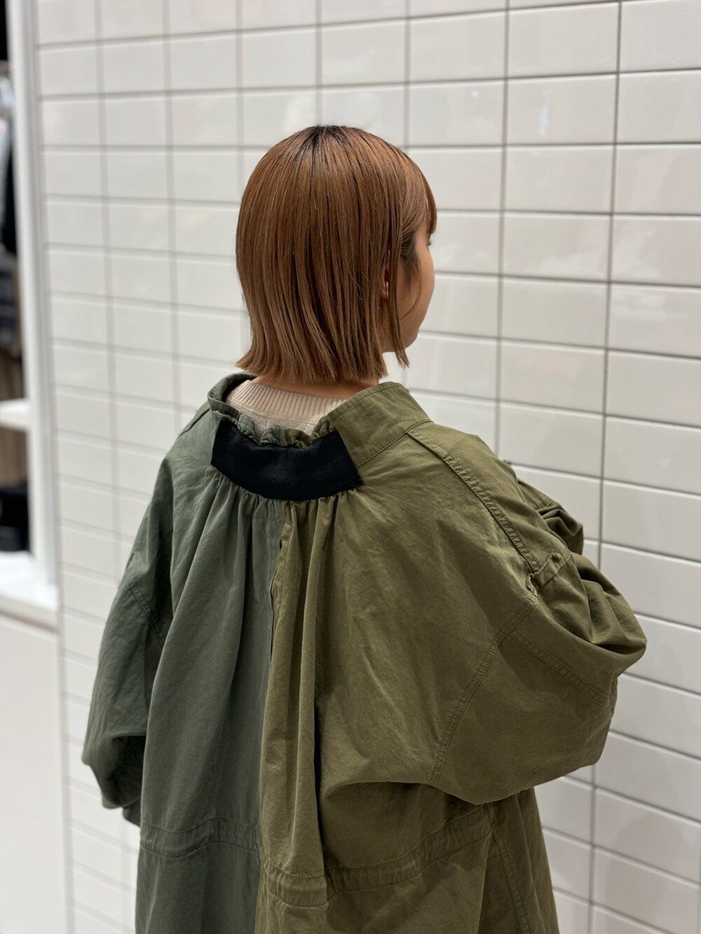 ブラック系のショルダーバッグ、ベージュ系のニット/セーター、グリーン系のモッズコートを着用したレディースの冬コーディネートの5枚目の写真