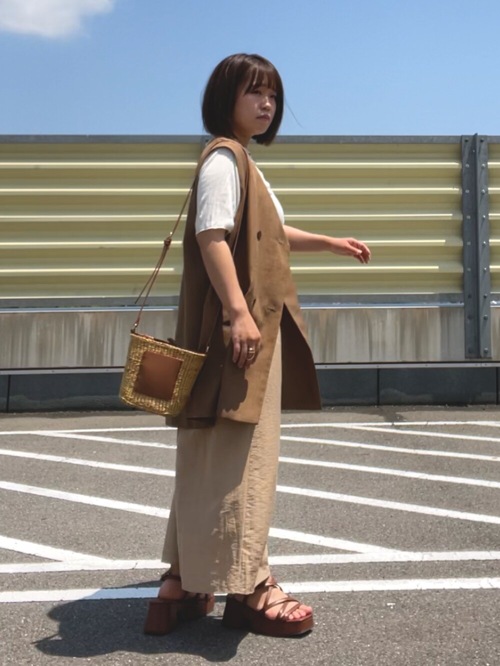 ホワイト系のTシャツ/カットソー、ブラウン系のベスト、ベージュ系のスカートを着用したレディースの夏コーディネートの2枚目の写真