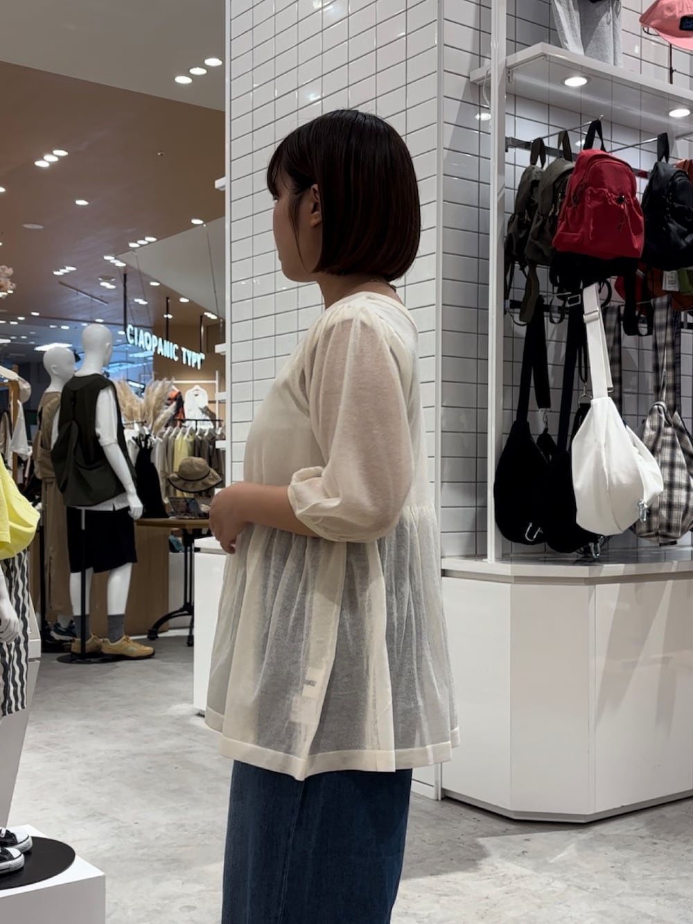 ホワイト系のニット/セーター、ホワイト系のタンクトップ、ブラウン系のトートバッグを着用したレディースの夏コーディネートの2枚目の写真