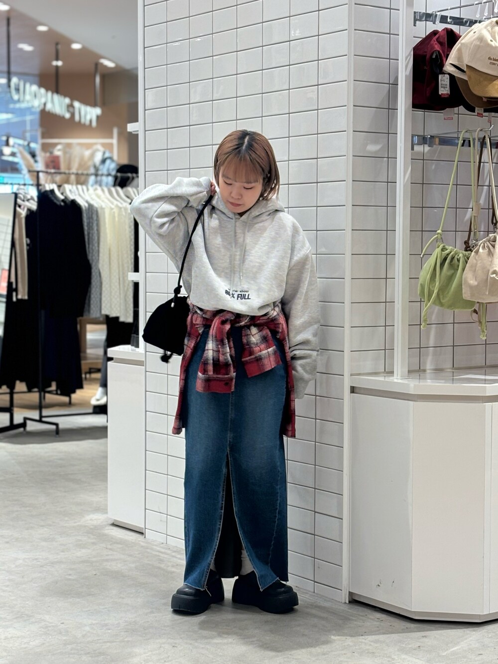 ブラック系のショルダーバッグ、グレー系のパーカー、レッド系のシャツ/ブラウスを着用したレディースの春コーディネートの2枚目の写真