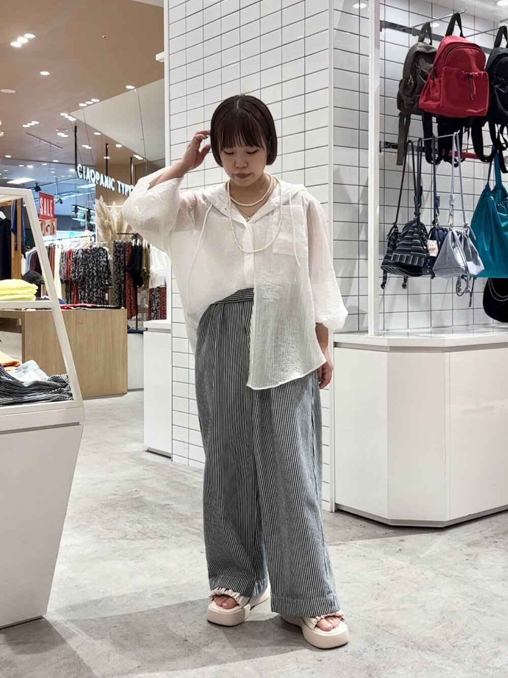 ホワイト系のサンダル、ブルー系のデニムパンツ、ホワイト系のシャツ/ブラウスを着用したレディースの夏コーディネートの2枚目の写真