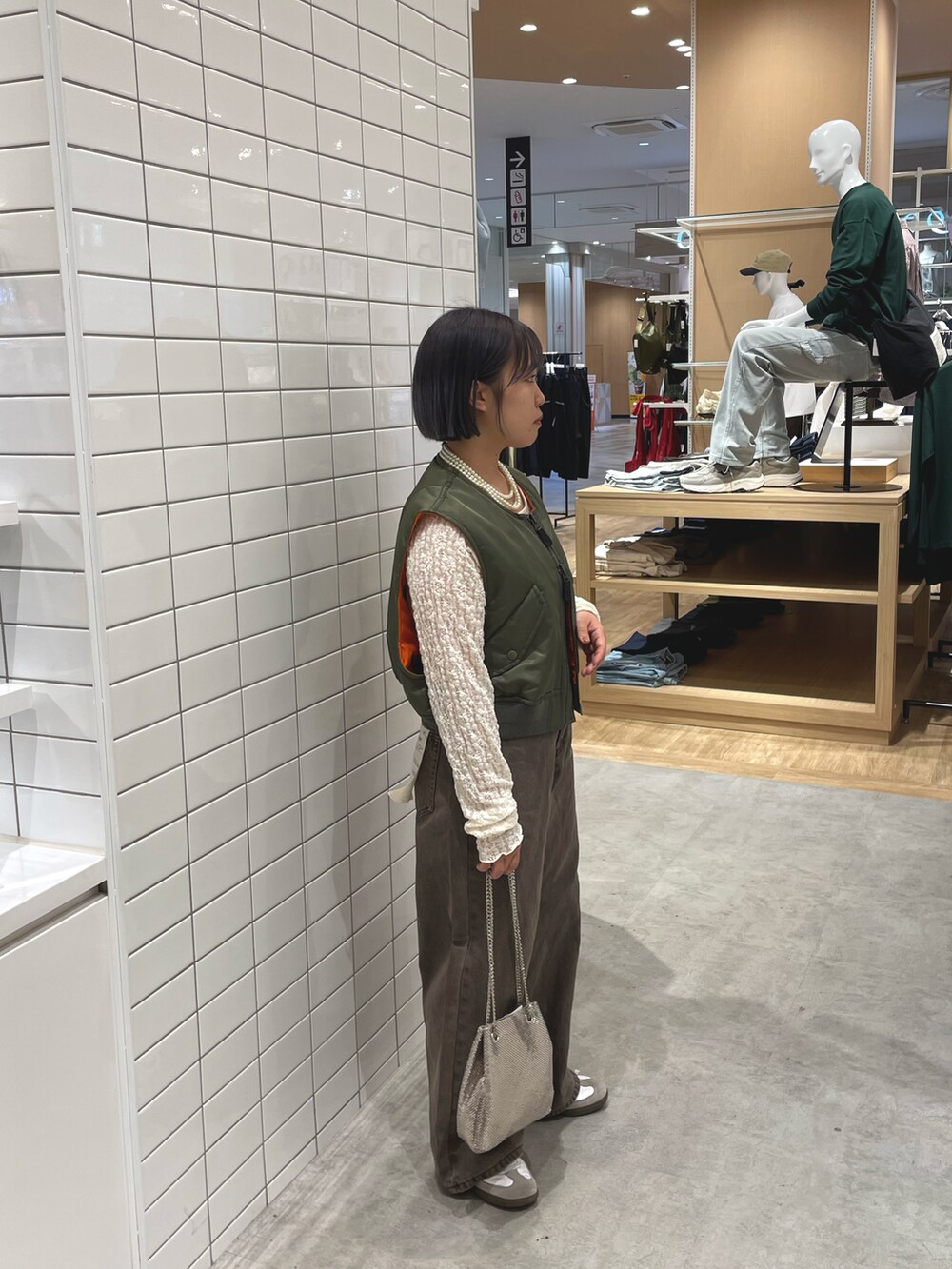 ホワイト系のスニーカー、ホワイト系のTシャツ/カットソー、グリーン系のジャケット/アウターを着用したレディースの秋コーディネートの2枚目の写真