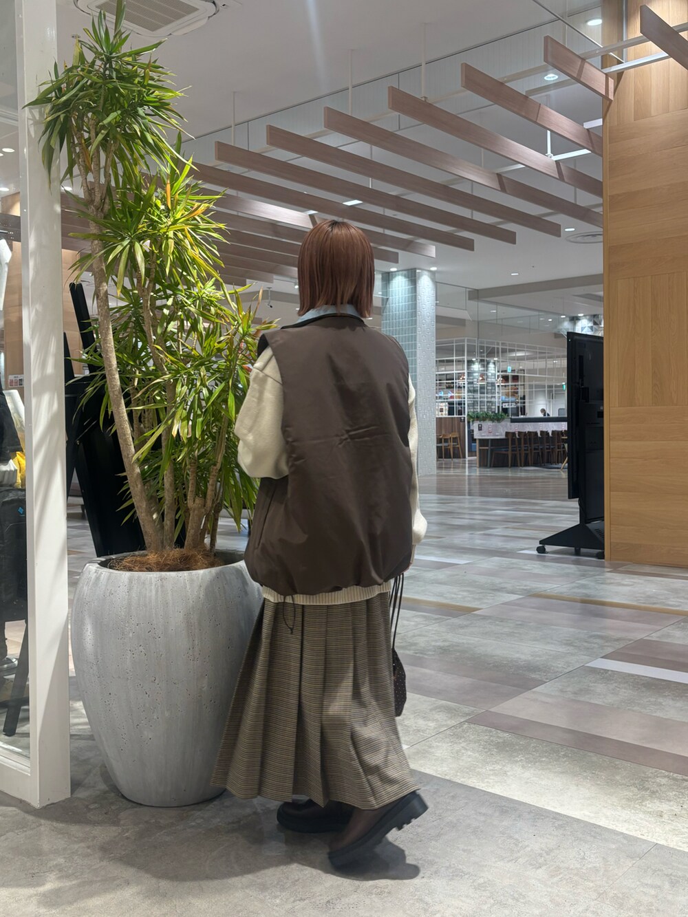ホワイト系のニット/セーター、ベージュ系のスカート、ブラウン系のショルダーバッグを着用したレディースの冬コーディネートの4枚目の写真