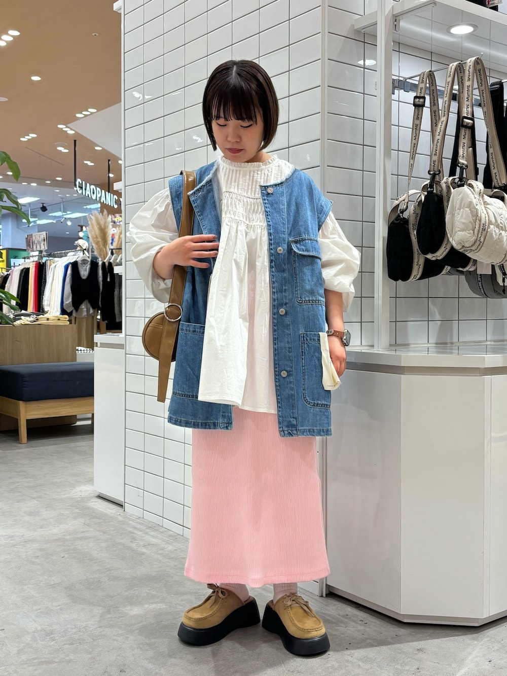 ブルー系のデニムジャケット、ベージュ系のショルダーバッグ、ホワイト系のシャツ/ブラウスを着用したレディースの春コーディネートの2枚目の写真
