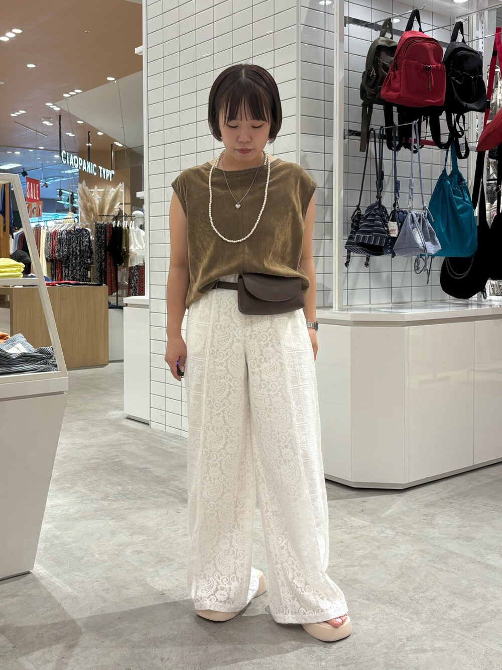 ホワイト系のサンダル、ホワイト系のその他パンツ、イエロー系のTシャツ/カットソーを着用したレディースの夏コーディネートの2枚目の写真