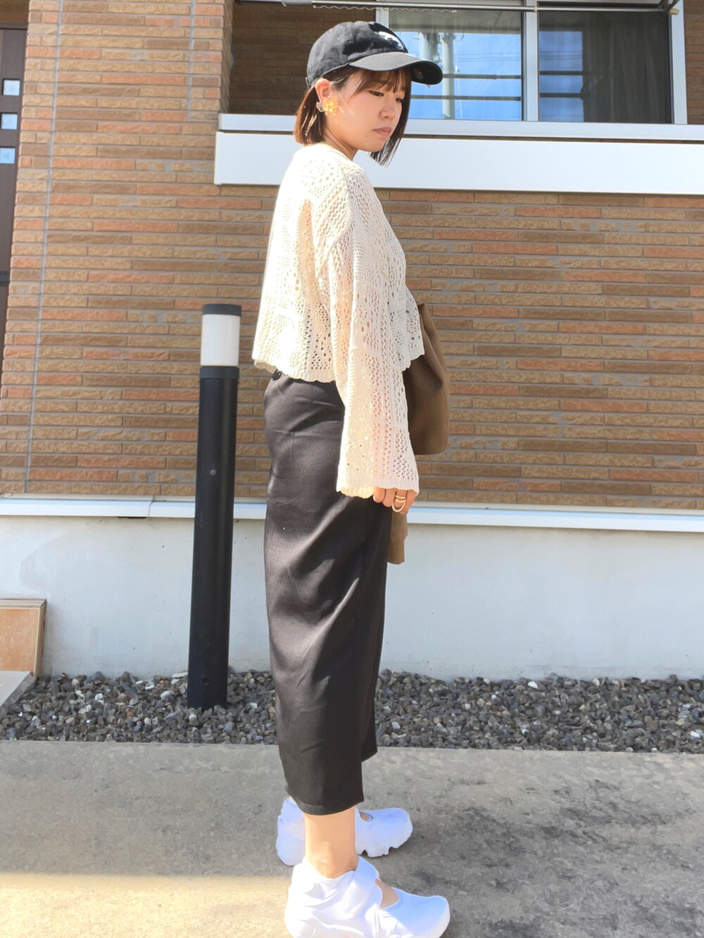 ベージュ系のニット/セーター、ブラック系のスカート、ブラウン系のベストを着用したレディースの春コーディネートの4枚目の写真