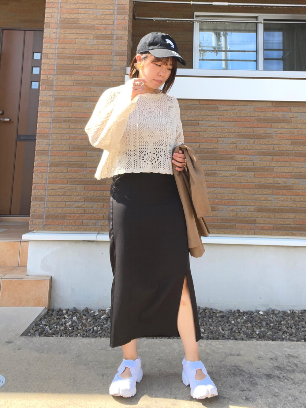 ベージュ系のニット/セーター、ブラック系のスカート、ブラウン系のベストを着用したレディースの春コーディネートの3枚目の写真