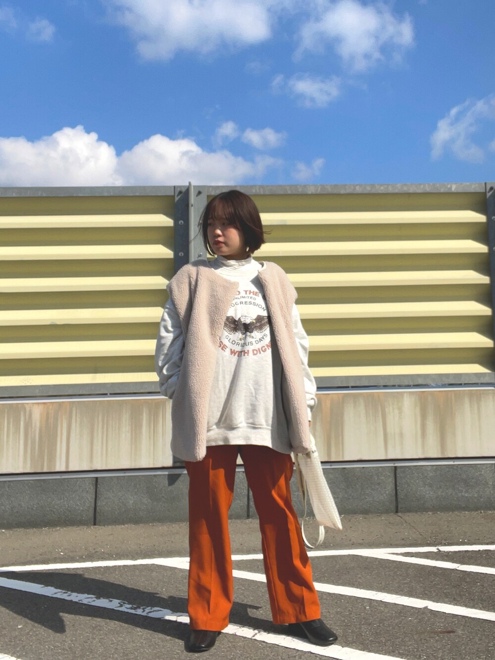 ブラウン系のスラックス、ブラック系のブーツ、その他のショルダーバッグを着用したレディースの冬コーディネートの3枚目の写真