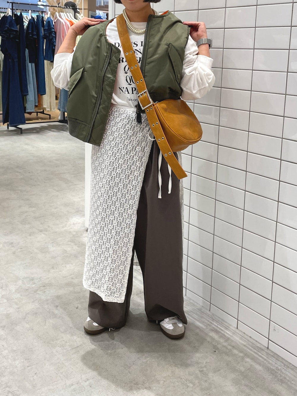 ホワイト系のスニーカー、ホワイト系のTシャツ/カットソー、グリーン系のジャケット/アウターを着用したレディースの秋コーディネートの3枚目の写真