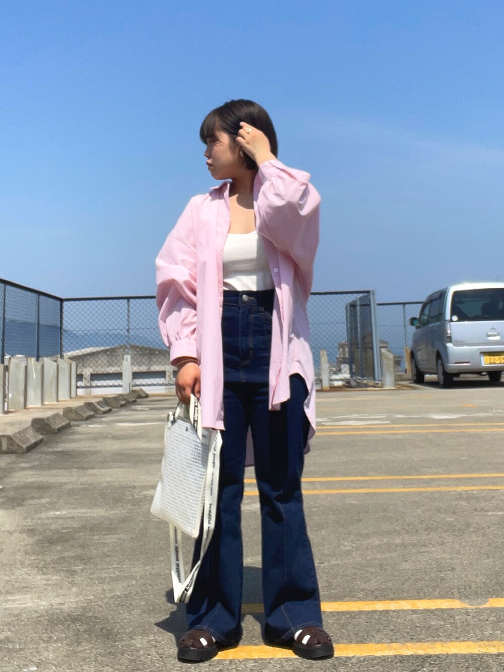 ホワイト系のタンクトップ、ピンク系のシャツ/ブラウス、ブルー系のデニムパンツを着用したレディースの春コーディネートの2枚目の写真