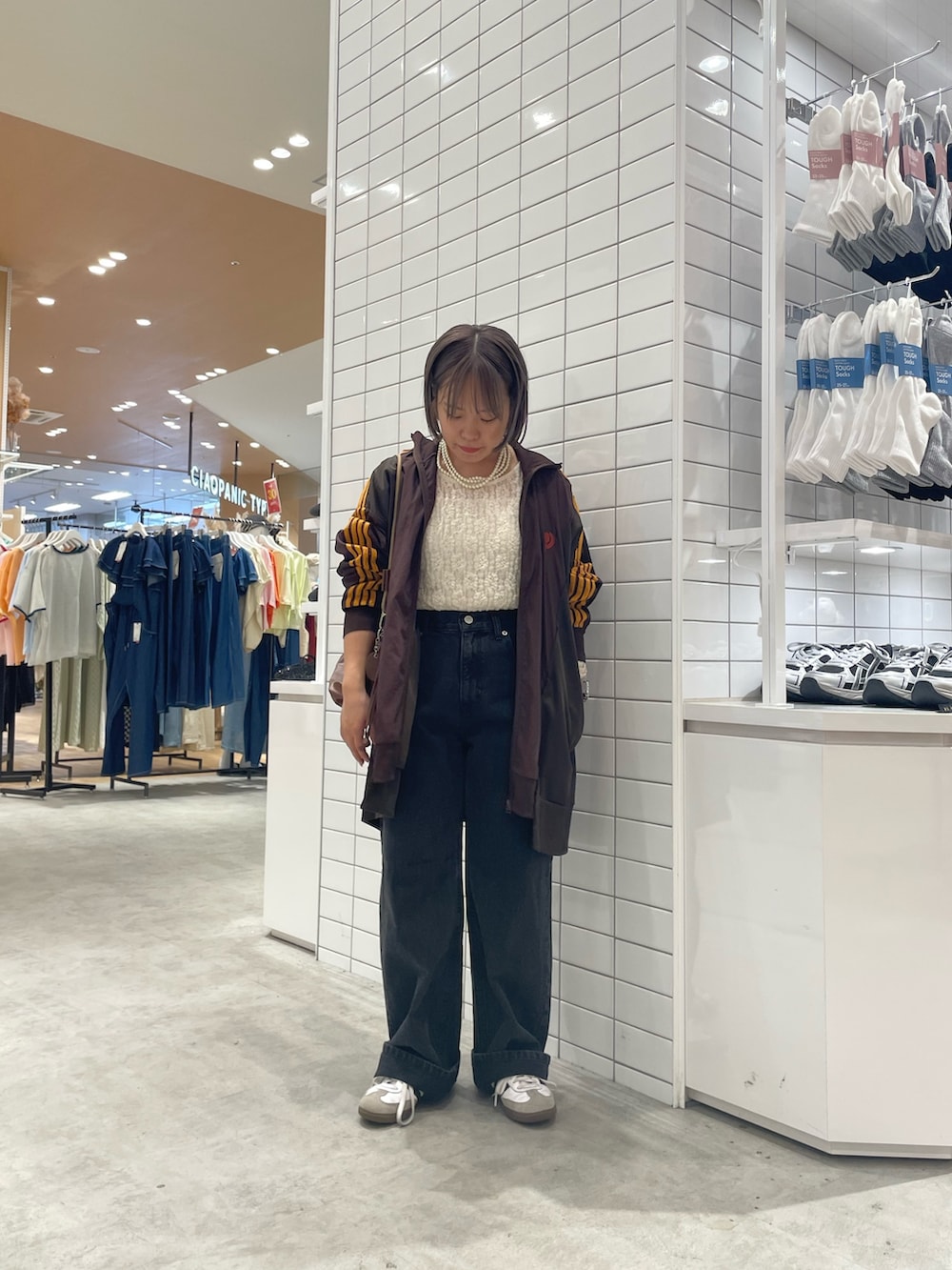 ホワイト系のTシャツ/カットソー、ブラウン系のジャケット/アウター、ブラック系のデニムパンツを着用したレディースの秋コーディネートの2枚目の写真