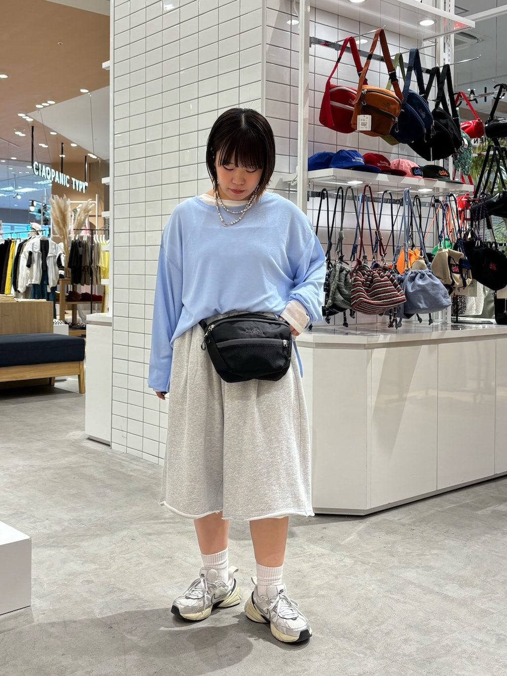 ブルー系のTシャツ/カットソー、ブラック系のボディバッグ/ウエストポーチ、グレー系のその他パンツを着用したレディースの春コーディネートの2枚目の写真