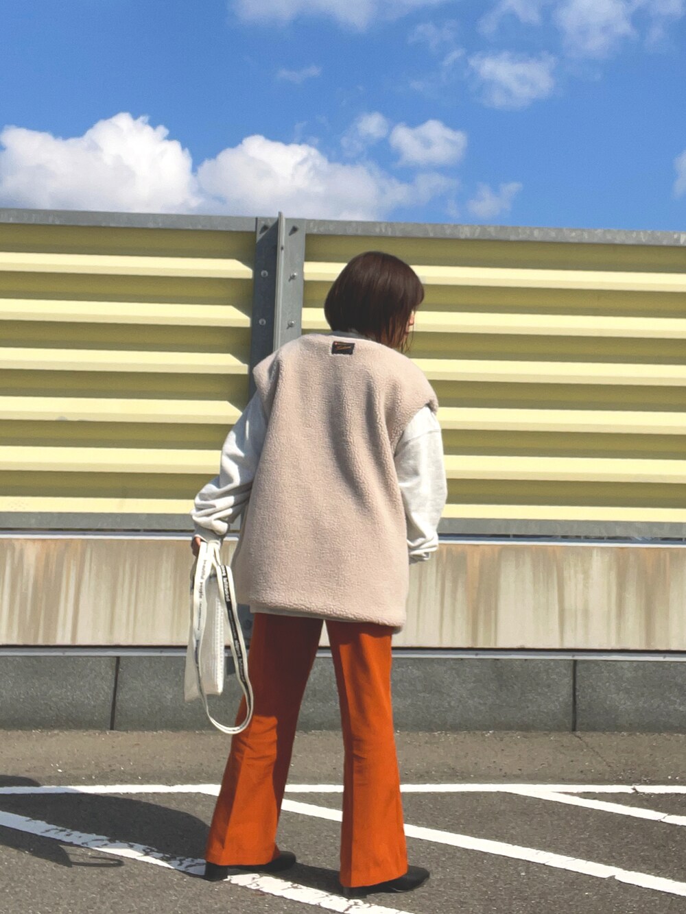 ブラウン系のスラックス、ブラック系のブーツ、その他のショルダーバッグを着用したレディースの冬コーディネートの4枚目の写真