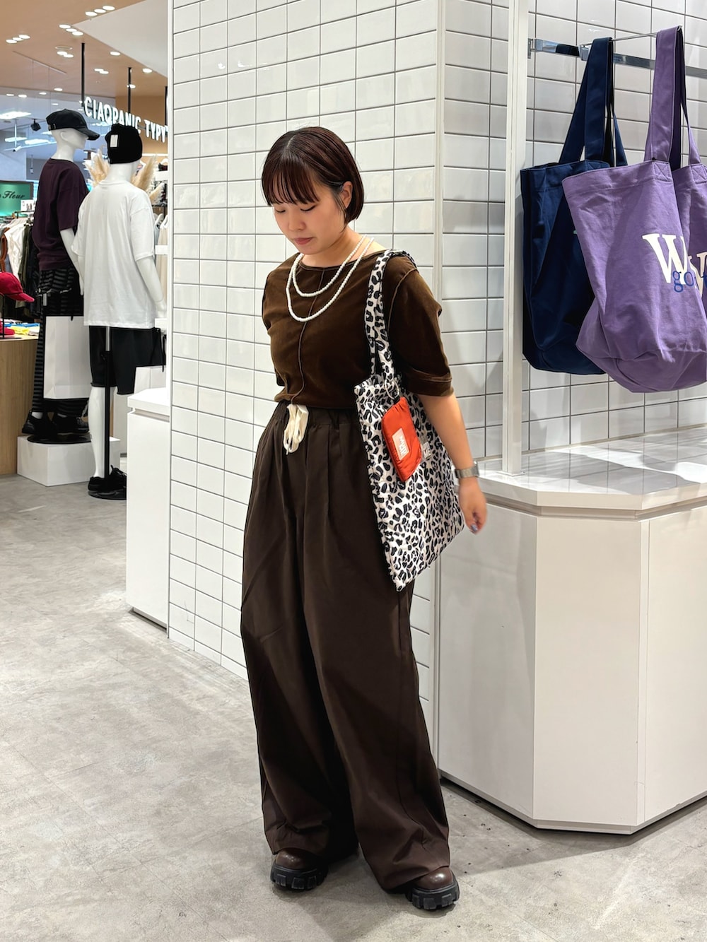 ブラウン系のデニムパンツ、ブラウン系のTシャツ/カットソー、ホワイト系のネックレスを着用したレディースの秋コーディネートの2枚目の写真