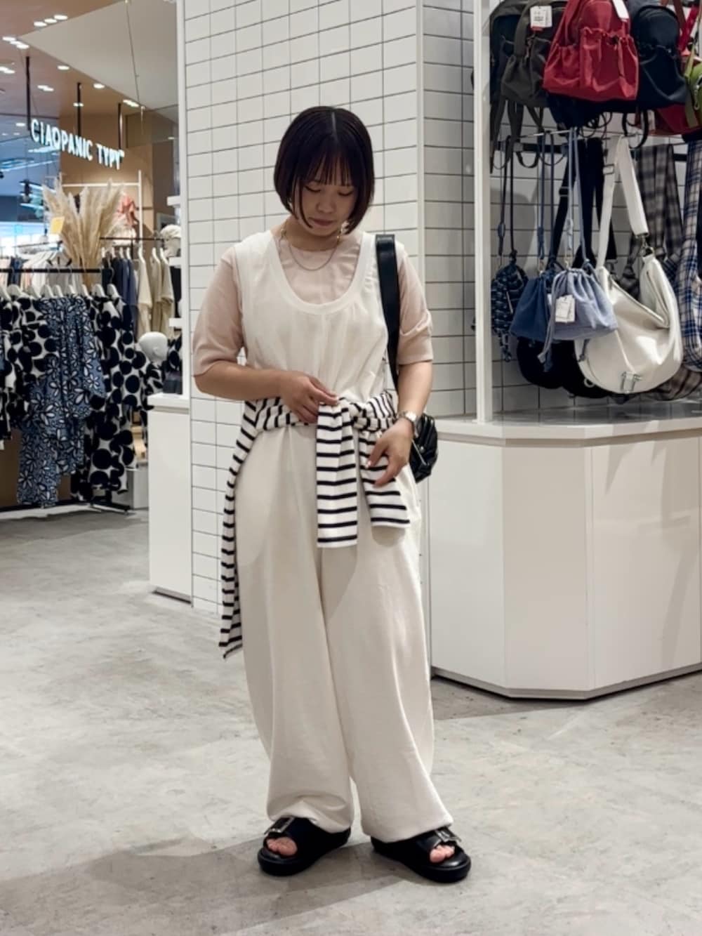 ホワイト系のサロペット/オーバーオール、ブラック系のサンダル、ホワイト系のTシャツ/カットソーを着用したレディースの夏コーディネートの2枚目の写真