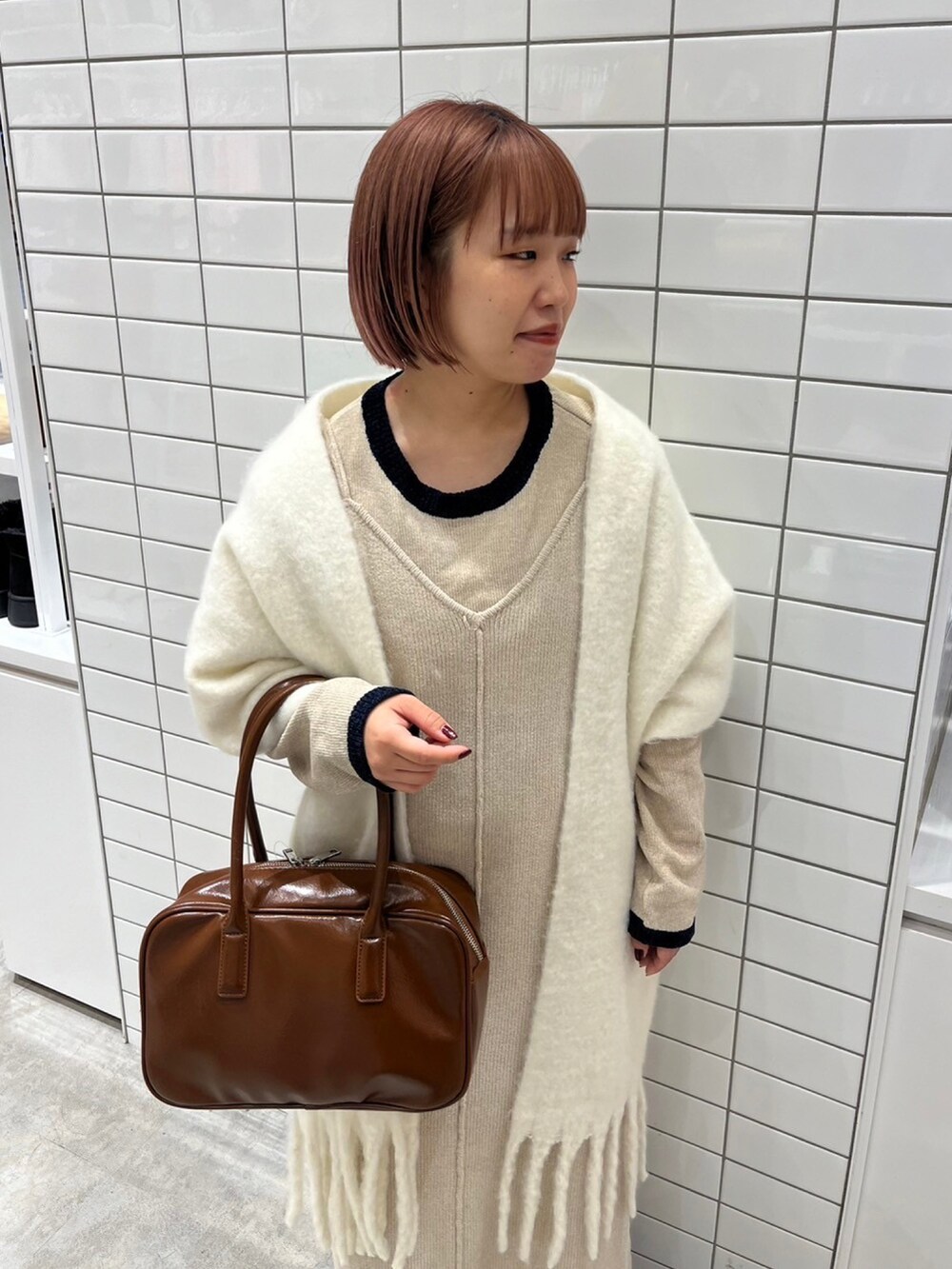 ホワイト系のワンピース、ブラウン系のボストンバッグ、ブラック系のブーツを着用したレディースの秋コーディネートの4枚目の写真