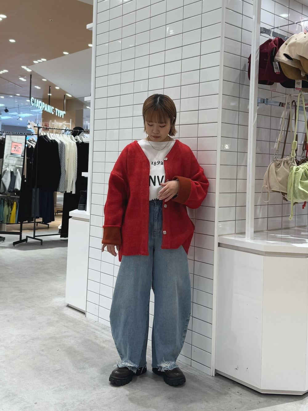 レッド系のカーディガン/ボレロ、ホワイト系のTシャツ/カットソー、ブルー系のデニムパンツを着用したレディースの春コーディネートの3枚目の写真