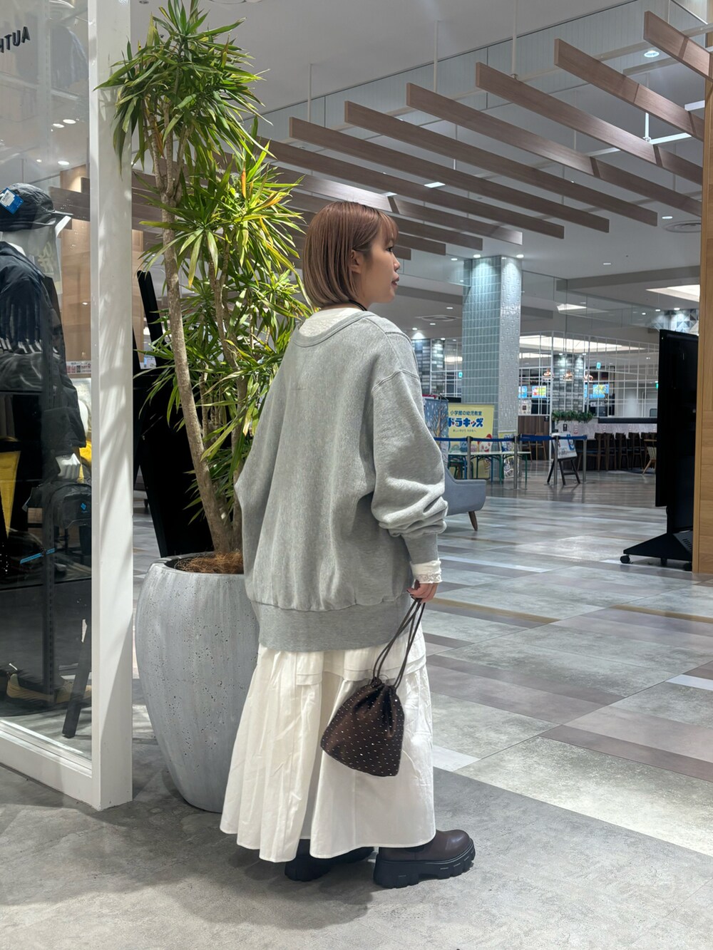 ブラウン系のショルダーバッグ、ホワイト系のワンピース、グレー系のスウェットを着用したレディースの冬コーディネートの3枚目の写真