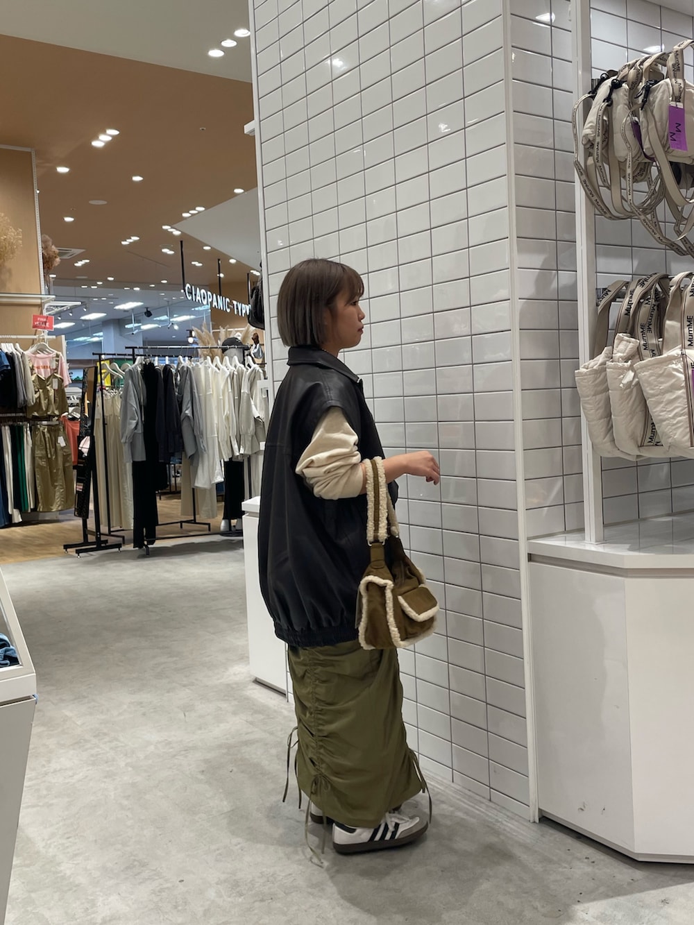 ホワイト系のスウェット、ブラウン系のライダースジャケット、ブラウン系のショルダーバッグを着用したレディースの秋コーディネートの3枚目の写真