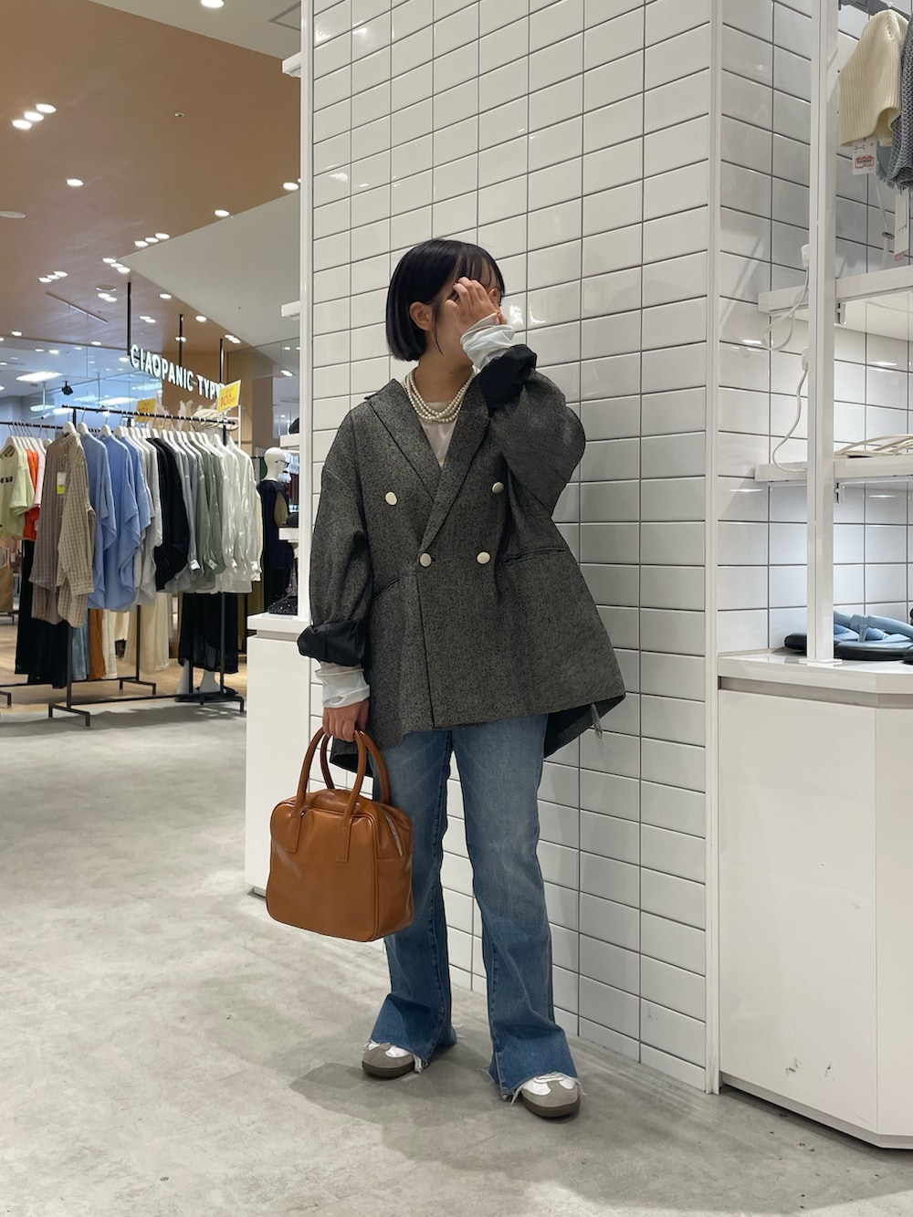 ホワイト系のスニーカー、ホワイト系のTシャツ/カットソー、ブラック系のテーラードジャケットを着用したレディースの秋コーディネートの2枚目の写真