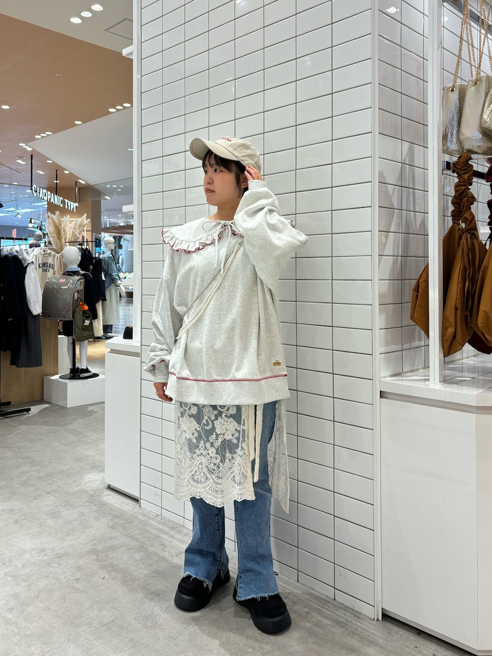 ホワイト系のスカート、ブルー系のデニムパンツ、ブラック系のサンダルを着用したレディースの春コーディネートの2枚目の写真