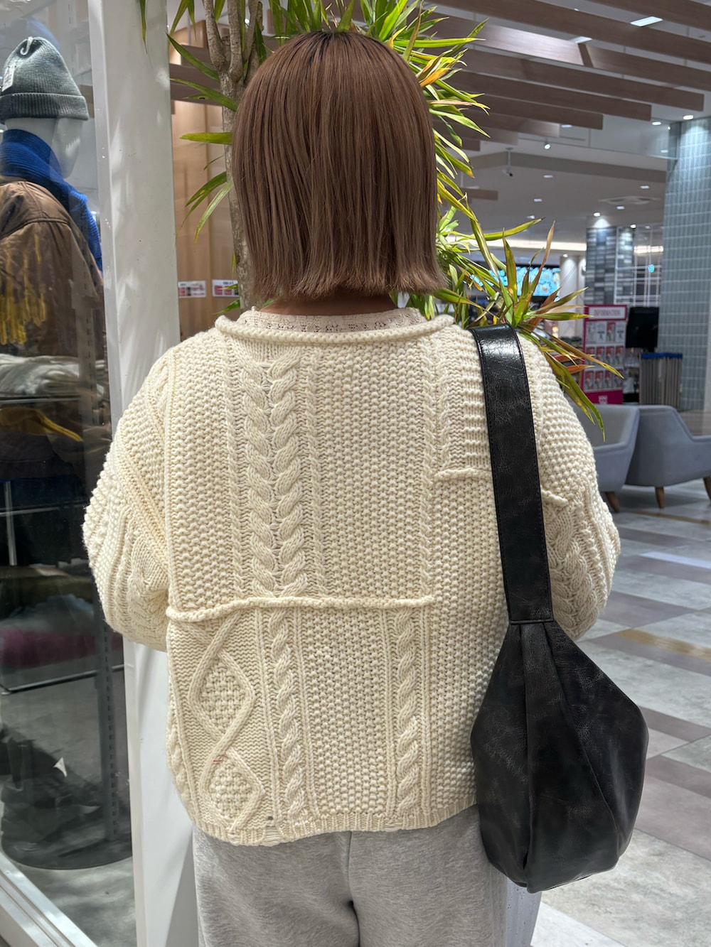 ブラック系のショルダーバッグ、グレー系のスウェットパンツ、ブラック系のブーツを着用したレディースの春コーディネートの3枚目の写真