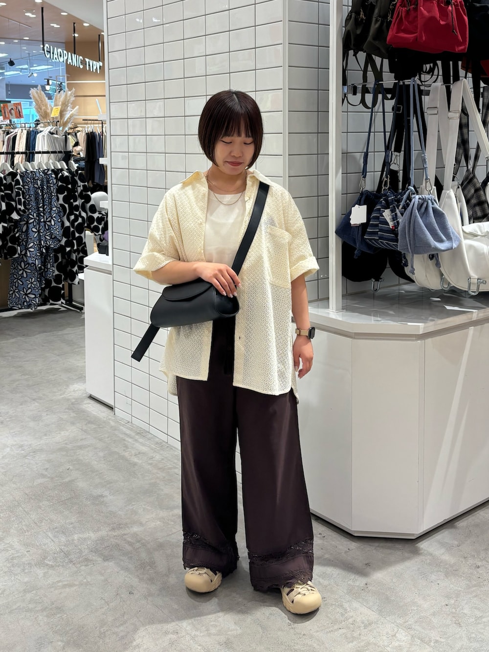 ホワイト系のニット/セーター、ブラック系のショルダーバッグ、ブラウン系のその他パンツを着用したレディースの夏コーディネートの2枚目の写真