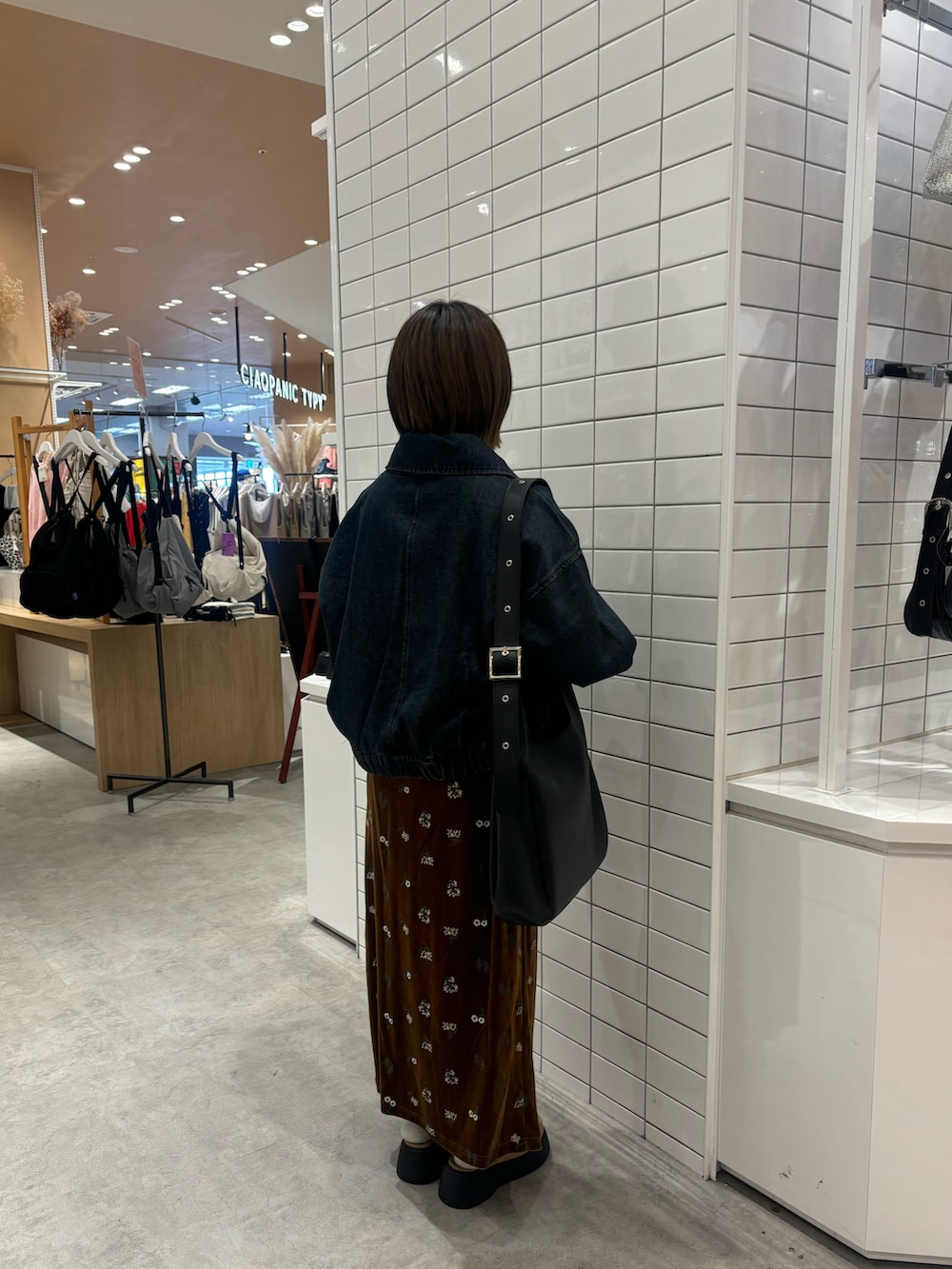 イエロー系のTシャツ/カットソー、ブルー系のデニムジャケット、ブラック系のスカートを着用したレディースの春コーディネートの3枚目の写真