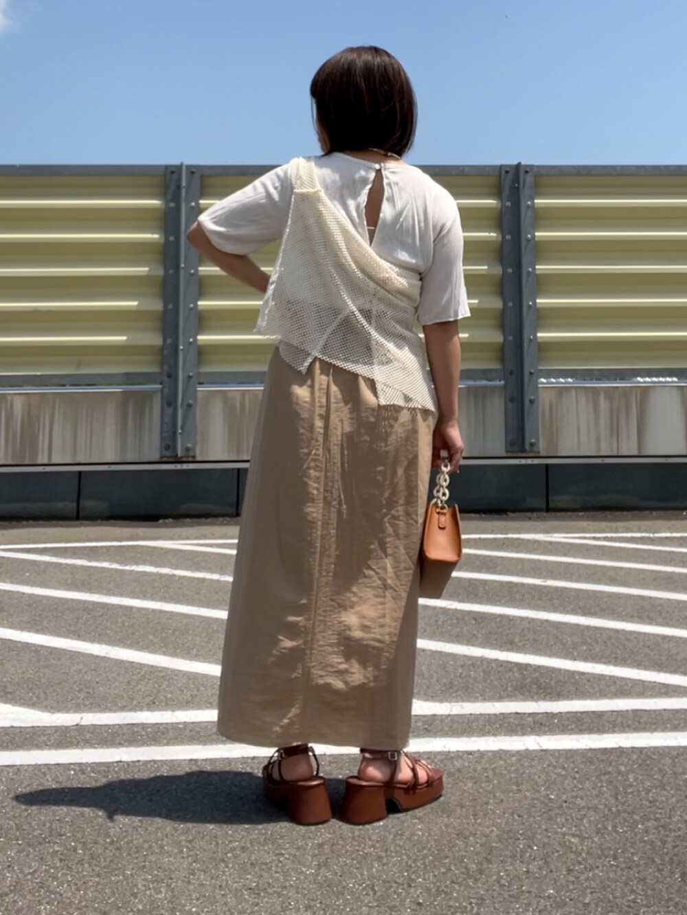 ブラウン系のサンダル、ベージュ系のスカート、ブラウン系のショルダーバッグを着用したレディースの夏コーディネートの5枚目の写真