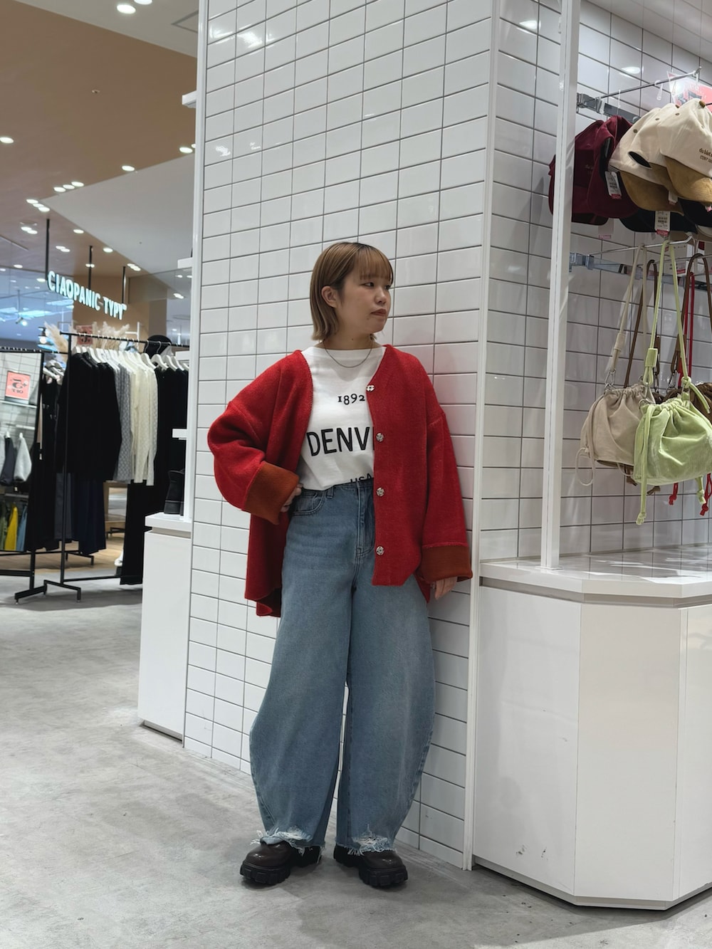 レッド系のカーディガン/ボレロ、ホワイト系のTシャツ/カットソー、ブルー系のデニムパンツを着用したレディースの春コーディネートの2枚目の写真