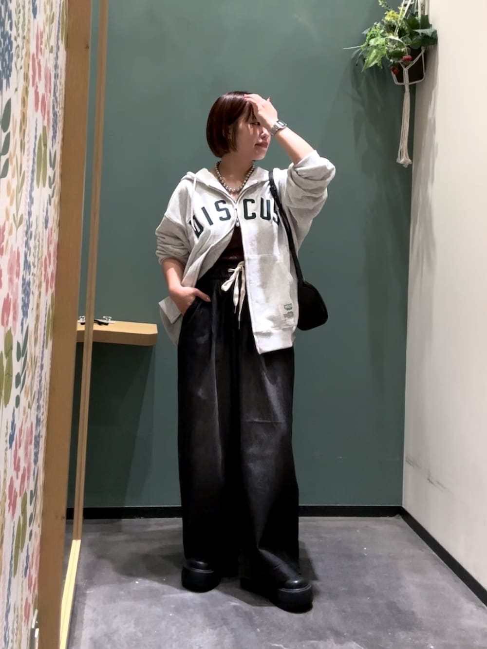 ブラック系のブーツ、ブラック系のデニムパンツ、グレー系のパーカーを着用したレディースの秋コーディネートの2枚目の写真