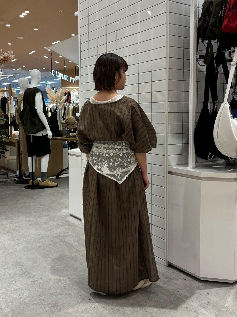 ホワイト系のタンクトップ、グレー系のワンピース、ベージュ系のサンダルを着用したレディースの夏コーディネートの2枚目の写真