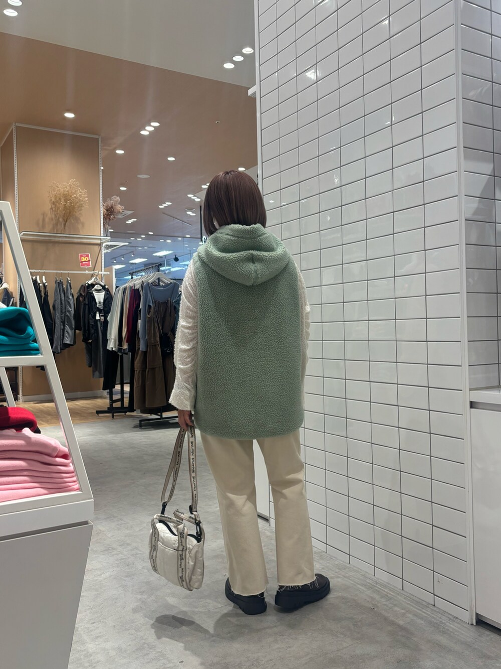 ホワイト系のTシャツ/カットソー、ホワイト系のデニムパンツ、ブラウン系のブーツを着用したレディースの秋コーディネートの3枚目の写真