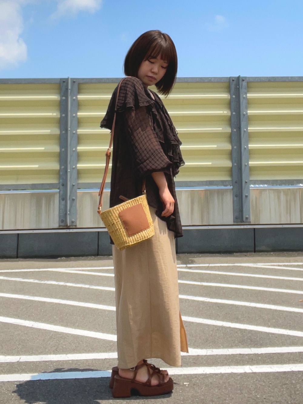 ブラウン系のシャツ/ブラウス、ベージュ系のバッグ、ベージュ系のスカートを着用したレディースの夏コーディネートの2枚目の写真