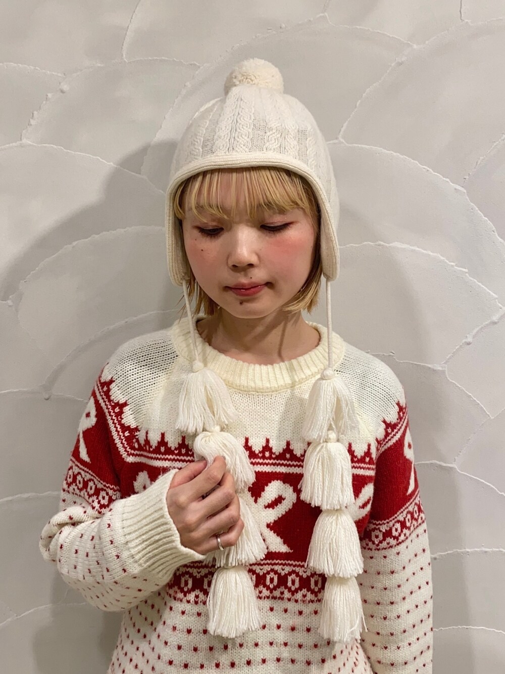 ホワイト系のニットキャップ/ビーニーを着用したレディースの冬コーディネートの2枚目の写真