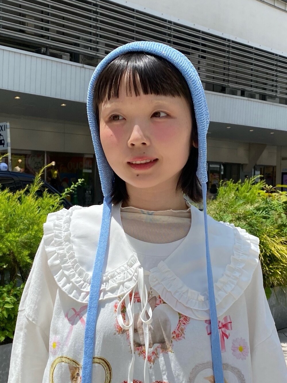 ブルー系のニットキャップ/ビーニーを着用したレディースの春コーディネートの2枚目の写真