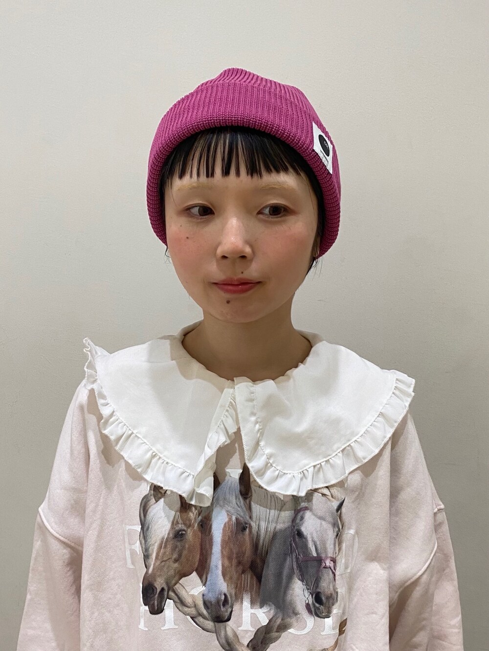 ピンク系のニットキャップ/ビーニーを着用したレディースの冬コーディネートの2枚目の写真