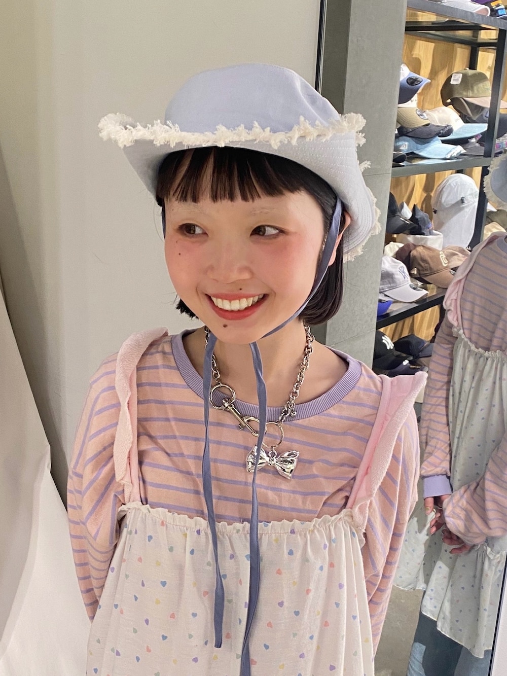 ブルー系のハットを着用したレディースの春コーディネートの2枚目の写真