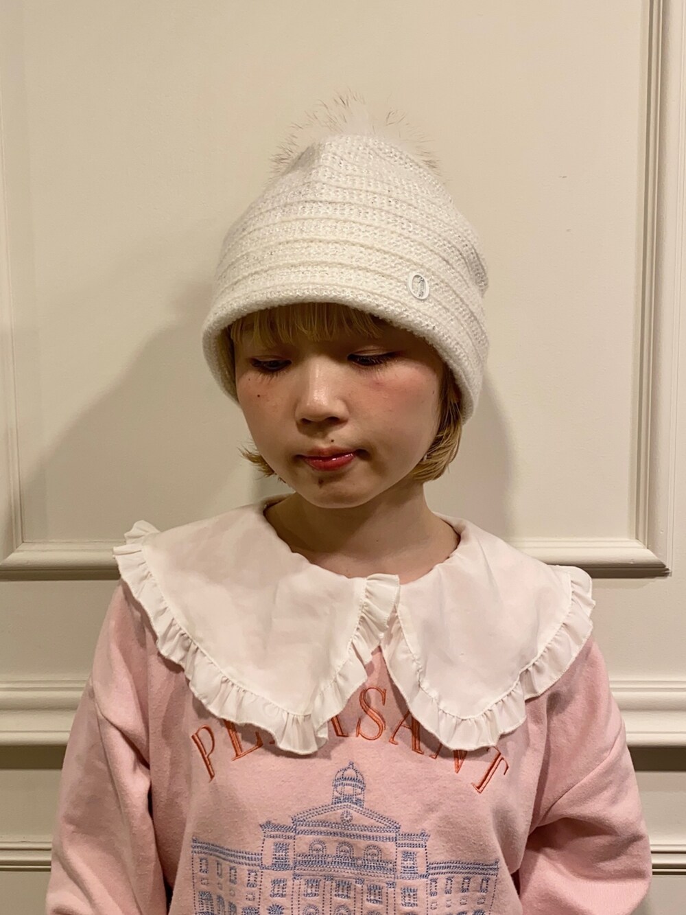 ホワイト系のニットキャップ/ビーニーを着用したレディースの冬コーディネートの2枚目の写真