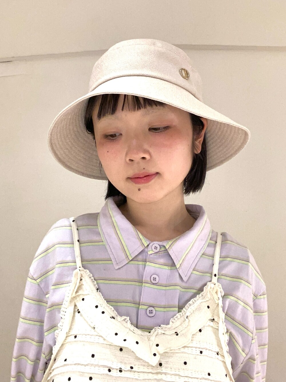 ベージュ系のハットを着用したレディースの春コーディネートの2枚目の写真