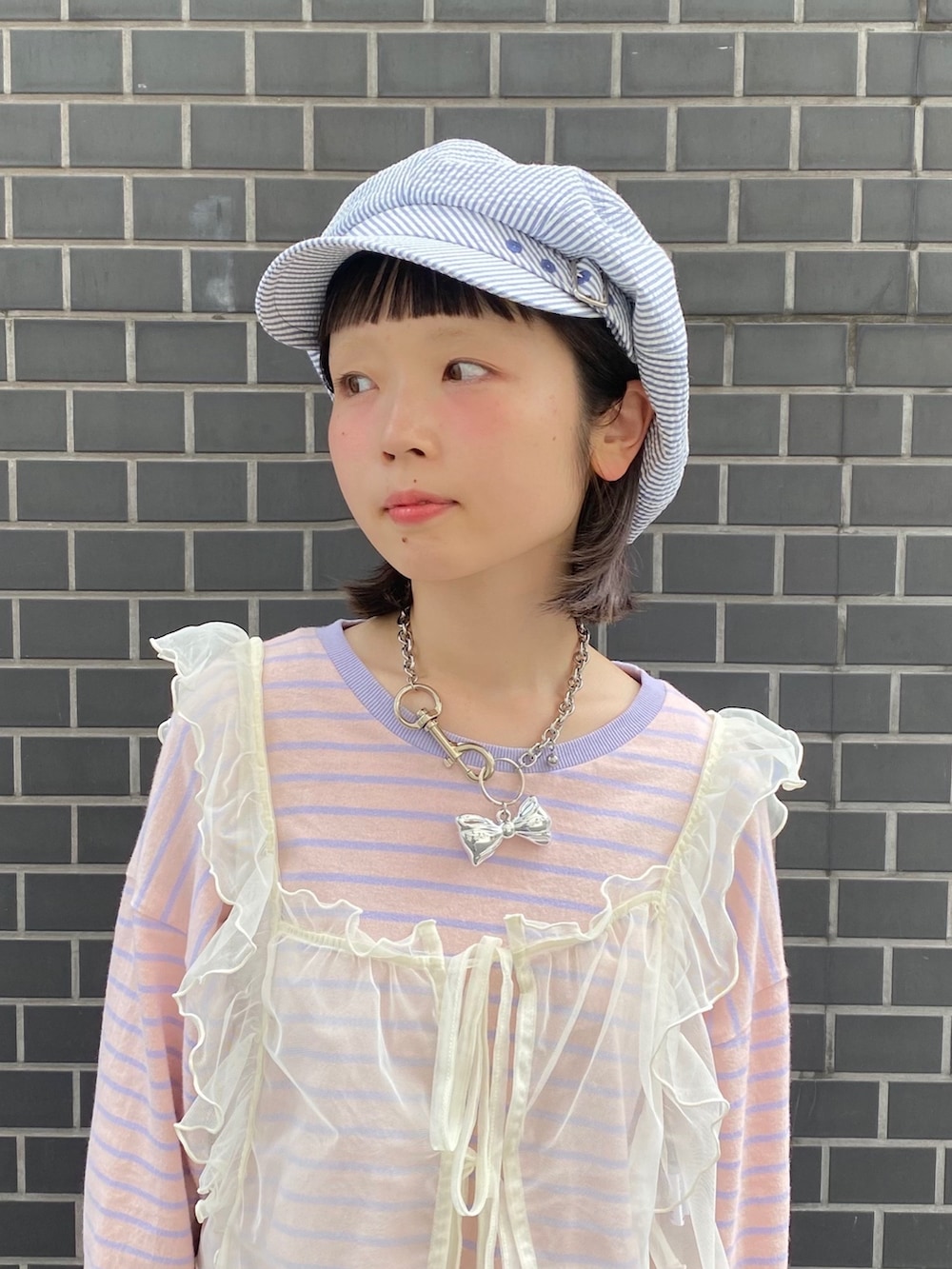ブルー系のキャスケットを着用したレディースの春コーディネートの2枚目の写真